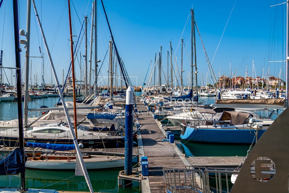 Pantalan con embarcaciones, al fondo pueblo marinero