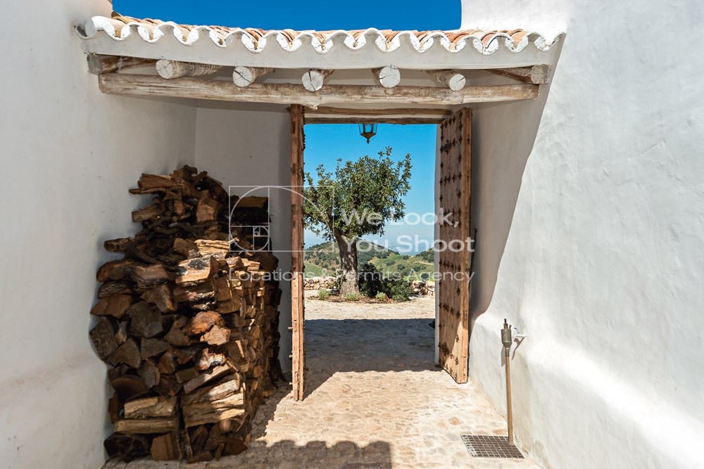 Entrada rústica con puerta de madera y leña